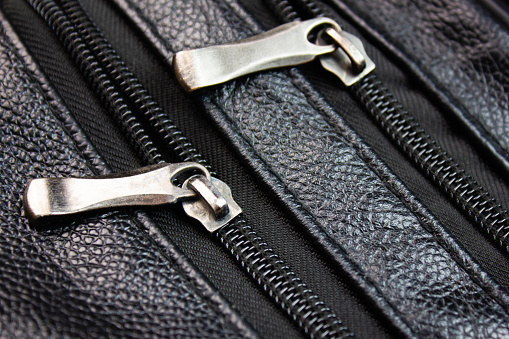 Metal clasp and zipper on the pocket of a leather purse or bag.