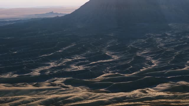 Sunlit Factory Butte And Its Barren Landscape In Wayne County, Utah. tilt-down shot