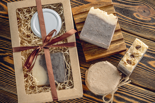 Craft set of natural cosmetics and natural soap. Pieces of organic coffee soap and handmade cream on the wooden table. Top view