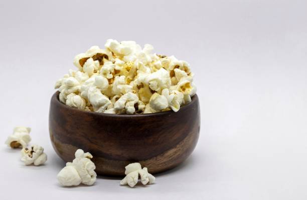 istock Popcorn in a Wooden Bowl Isolated on White Background with Copy Space 2044479940