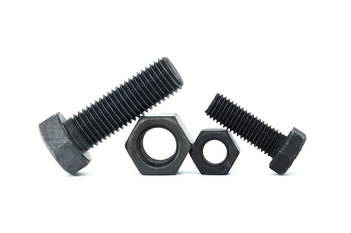 Orderly arrangement of dark-colored metal of hex bolts and nuts include long and shorter parts, placed against a clean, white background