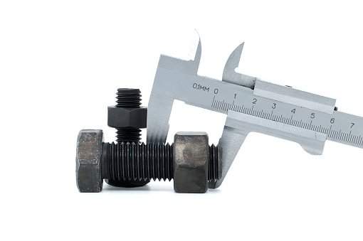Caliper measure two adjacent black bolts with hexagonal heads, lying on a white background