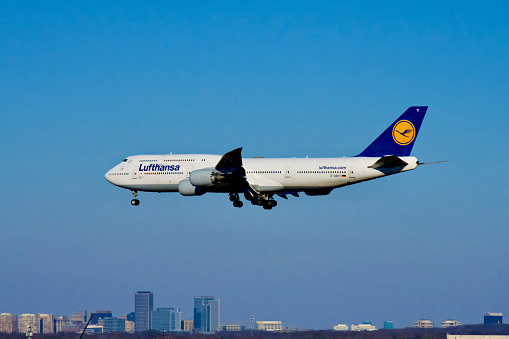 Chantilly, Virginia, USA - February 19, 2024: The Reston Town Center can be seen in the background as a Lufthansa Boeing 747-830 flight enroute from Frankfurt, Germany, prepares to land at Washington Dulles International Airport.