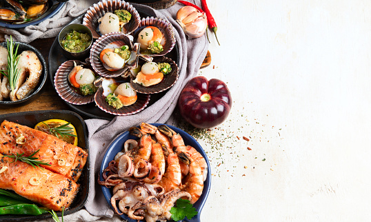 Set of Seafood dishes on light wooden background. Top view, copy space