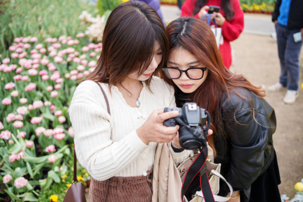 istock Asian tourists looking at camera photos 2044577462