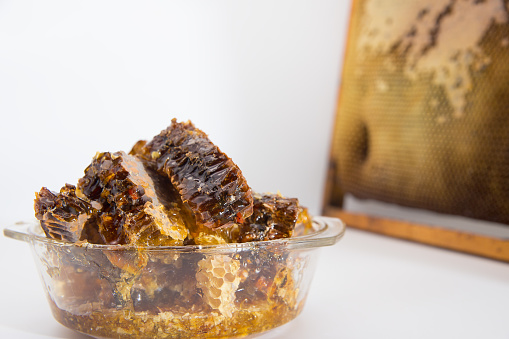 Honey of wild bees in honeycombs. Honey honey lies in a glass bowl.