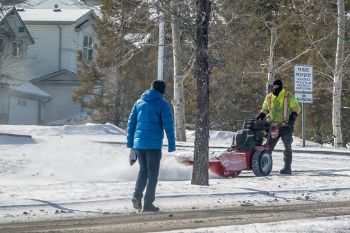 Calgary, Alberta, Canada. Feb 25, 2024. An individual utilizing a snow removal machine to clear snow effectively and efficiently.