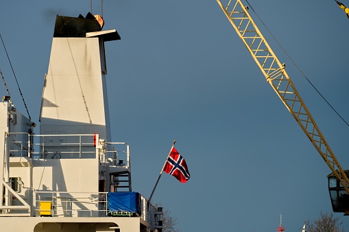 Norway flag on the stern of the ship. Norwegian ship in port.