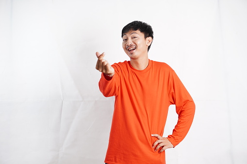 Asian young man making little heart hand sign isolated on white background.
