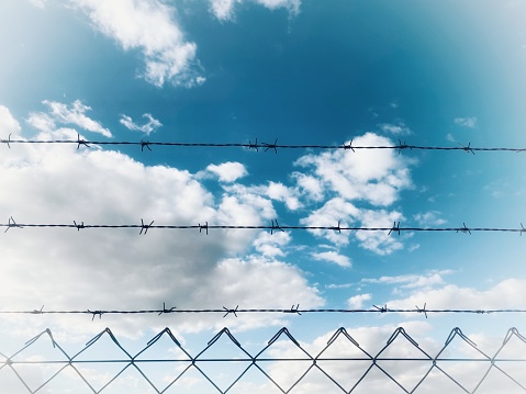wire fence with blue sky, in a warehouse surrounded by an iron fence
