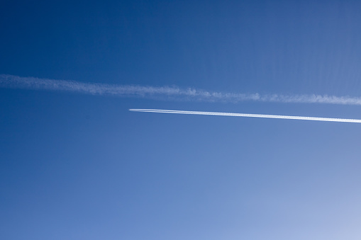 the white trails of the planes in the blue sky