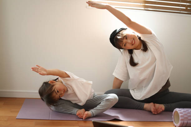 istock Parent and child doing yoga at home 2044719619