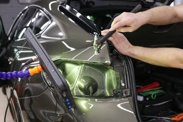 Car body repair without painting. A specialist repairs a dent on the car body without painting. The mechanic at the auto shop with tools to repair dents. Removing dents on the car. PDR technology. reparación de carrocerías sin pintar. un especialista repara una abolladura en la carrocería del automóvil sin pintar. el mecánico del taller mecánico con herramientas para reparar abolladuras. eliminación de abolladuras en el coche. tecnología pdr