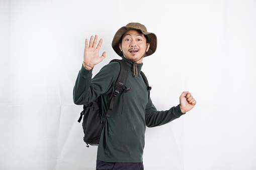 Young man standing over white background waiving saying hello happy and smiling, friendly welcome gesture. Hi five and traveling concept
