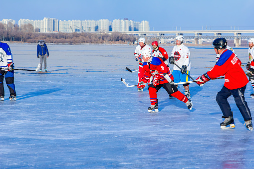 Harbin, Heilongjiang, China - December 6th 2018 - Photo of people playing ice hockey on outdoor rink in winter
