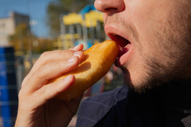 istock male man eating fried pie with potatoes close-up outside 2044739321