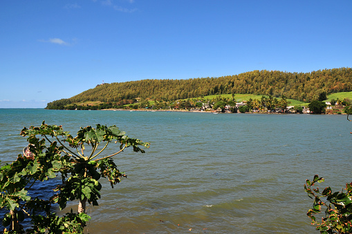 Petit Sable, Grand Port District, Mauritius, Mascarene Islands: north shore of the Pointe du Diable headland (Devil's Point!), with the Petit Sable hamlet, seen from across the bay, with papaya trees on the left.