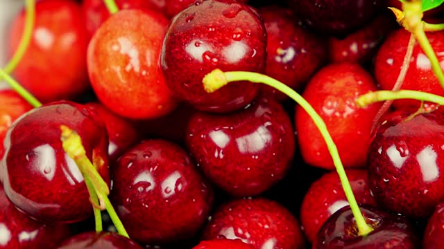 Fresh Ripe Cherries With Water Droplets Rotating In A White Bowl