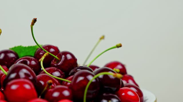 Fresh Ripe Cherries With Water Droplets Rotating On A White Background