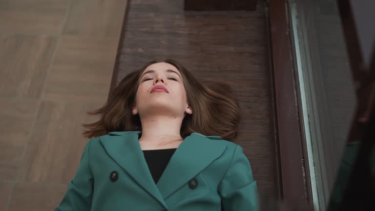 Drained woman leans against windowsill