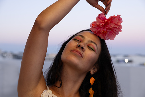 Vibrant South American Woman Holding A Flower in the Head in an Early Evening