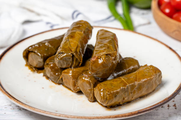 istock Stuffed grape leaves with olive oil. Dolma prepared with grape leaves and rice. Stuffed grape leaves or dolmades with olive oil on a white wooden background. local name yaprak sarma. Close up 2044832089