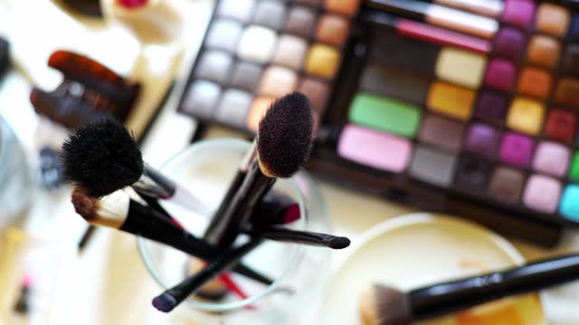 A Set Of Makeup Brushes, Beauty Products And Eyeshadow Palette Arranged On A Desk At The Beautician's Salon