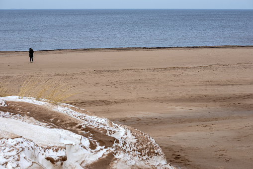 The coast of the Baltic Sea with snow through the sand