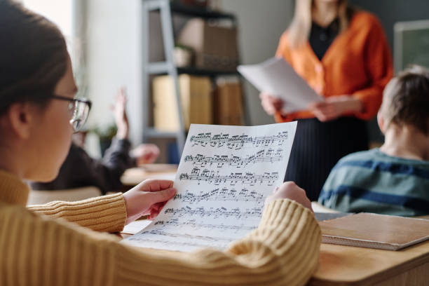 menina olhando para partituras durante a aula - sheet music music classroom education - fotografias e filmes do acervo