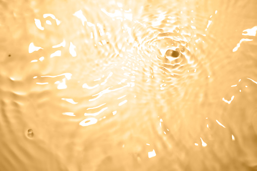 Photograph of soft, natural orange-brown water waves.