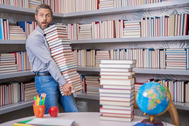 istock education and knowledge. back to school. teachers day. teachers education in school. knowledge day. Reading for pleasure. man get university education. school education with man teacher 2044906399