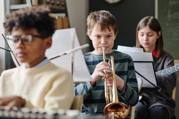 istock Boy Playing Trumpet In Orchestra At School 2044928180