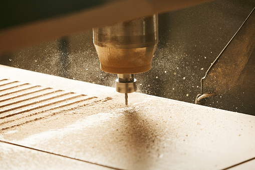 Close-up shot of machine with numerical control cuts wood. Cnc tool. Woodworking industry.