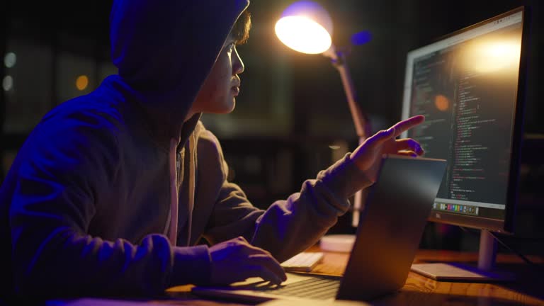 Young male programmer working late night to finish coding on his project at his office