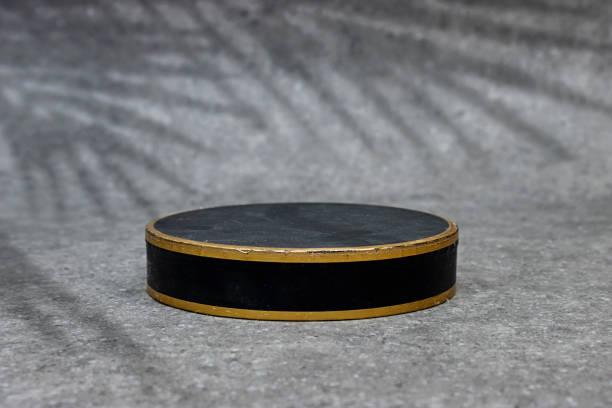 Abstract empty black podium with leaves shadow on grunge gray background. Mock up stand for product presentation. Minimal concept. Advertising template