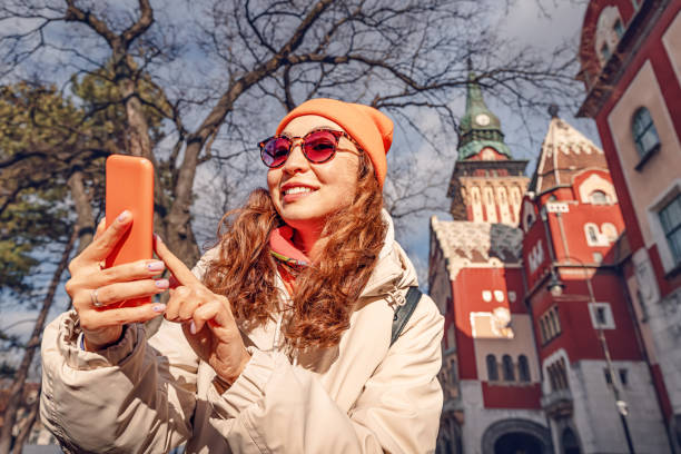 istock Tourist girl using map applications on her smartphone against Subotica town hall, while travelling in Serbia 2044948960