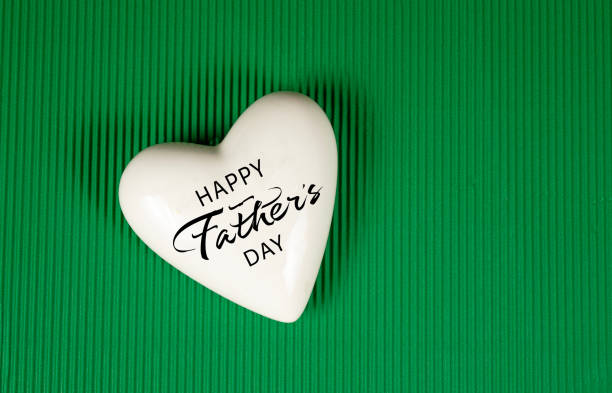 Happy Father's day design on heart with green background.