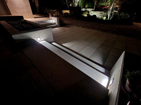lighting of stairs and steps on the concrete wall on the side of the stairs. recessed reflectors shine underfoot and create a clear and safe scene for movement at night. hotel exterior of the resort