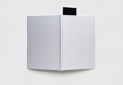 A blank book with a black bookmark on a white background