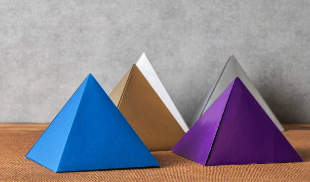 Conceptual still life with paper pyramids.