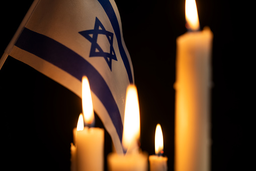 Burning candles and Israel flag with Star of David