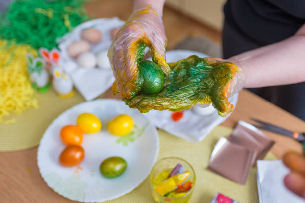 istock Easter egg painting.woman coloring easter eggs in the kitchen at home. 2044996559