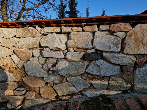 repaired renovated sandstone walls near the cemetery. stairs and railings of the wall made of new stone which weatheres quickly but is beautiful and beige from large easily workable blocks.  sloping