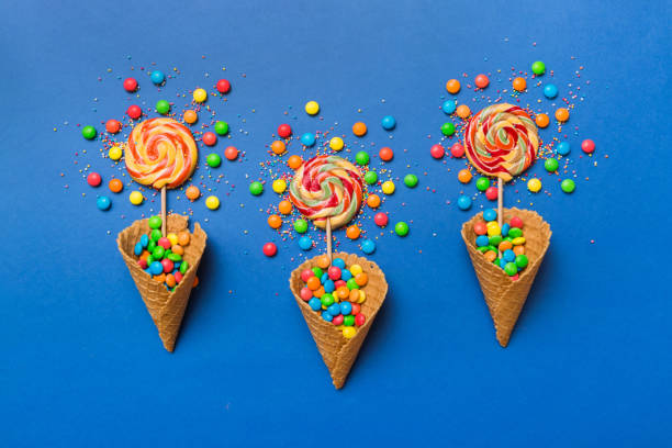 istock waffle cone full of assorted traditional candies falling out on colored background with copy space. Happy Holidays sale concept 2045027015