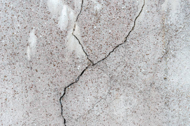 istock Cracked concrete wall gray cement surface background.cracked grey stone wall in winter.close-up. 2045029184