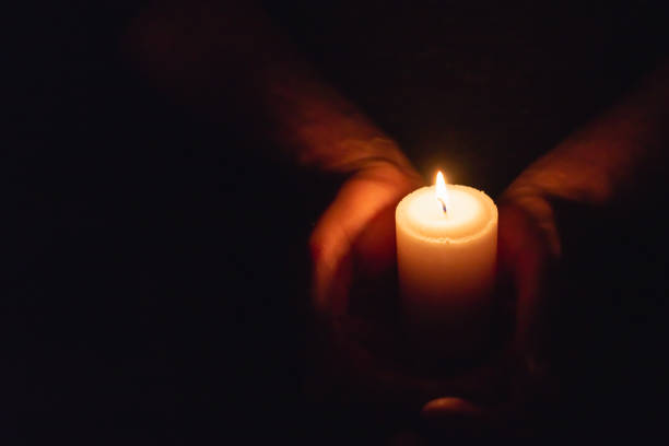 istock Hands holding burning candle in dark like a heart.Selective focus,black background.Copy space. 2045057248