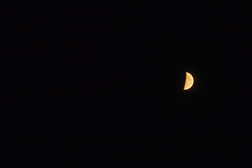 One half moon in the dark sky.Night Evening Sky Blue Moon.Copy space.Soft focus.Blurred image.