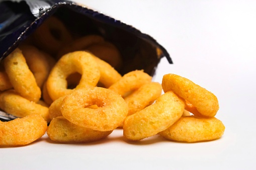 Crispy ring snacks, coming out of the packaging, on a white background
