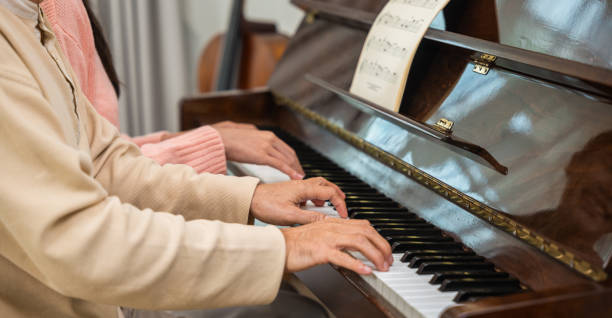istock Young woman teaching piano for senior man teaching 2045080942