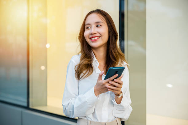 istock Woman with mobile next to buildings 2045080956